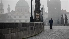 Turistka prochází po opuštěném Karlově mostě v Praze. (18. března 2020) Turistka prochází po opuštěném Karlově mostě v Praze. (18. března 2020)