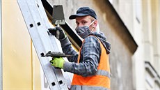 Řemeslník opravuje fasádu na Masarykově ulici v Brně. (27. března 2020) Řemeslník opravuje fasádu na Masarykově ulici v Brně. (27. března 2020)