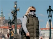 Žena v roušce při procházce přes Karlův most v Praze. (1. dubna 2020)