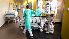 Zdravotnice tlačí lůžko s pacientem nakaženým onemocněním covid-19 na jednotce... Zdravotnice tlačí lůžko s pacientem nakaženým onemocněním covid-19 na jednotce...