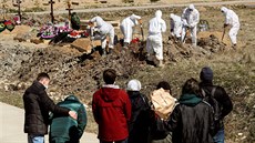 Příbuzní jedné z obětí onemocnění covid-19 truchlí během pohřbu ve vyhrazené... Příbuzní jedné z obětí onemocnění covid-19 truchlí během pohřbu ve vyhrazené...