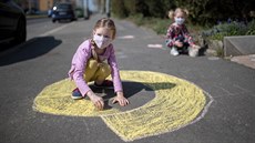 Dívky v rouškách si hrají před domem na pražských Petřinách. (16. dubna 2020) Dívky v rouškách si hrají před domem na pražských Petřinách. (16. dubna 2020)