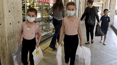 Dvě holčičky si nesou tašky z nákupů, které podnikly v módním obchodním domě v... Dvě holčičky si nesou tašky z nákupů, které podnikly v módním obchodním domě v...