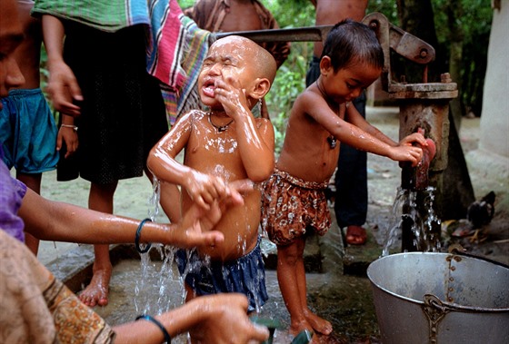 Lidé z vesnice Jhikargacha v Bangladéi se myjí pod erven oznaenou pumpou,...