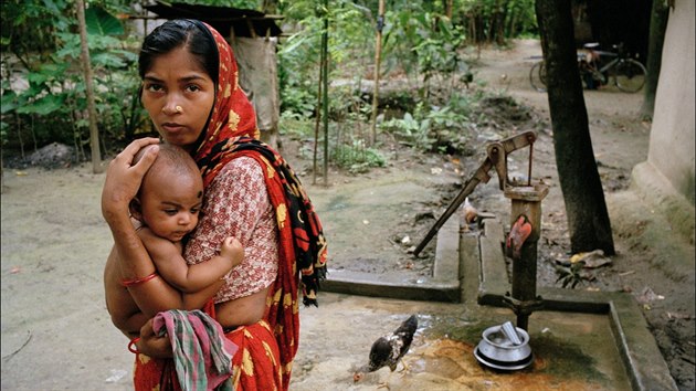 ena z vesnice Jhikargacha v Bangladi s ernmi jizvami na pach a bocch, pznakem otravy arsenem. Jedin zdroj pitn vody pro ni pedstavuje erven oznaen pumpa, co znamen, e voda je kontaminovna arznem. (15. ervna 2000)
