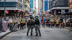 Policejní hlídka v Hongkongu zadržuje dav protestující proti novému zákonu.... Policejní hlídka v Hongkongu zadržuje dav protestující proti novému zákonu....
