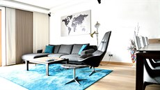 Obývací pokoj v neutrálních barvách  barevn oivuje tyrkysový koberec.