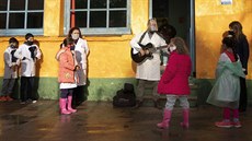Ředitel základní školy zpívá žákům, kteří přišli první den po znovuzavedení... Ředitel základní školy zpívá žákům, kteří přišli první den po znovuzavedení...