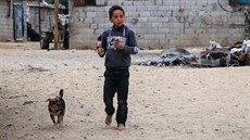 Chlapec si hraje se psem ped svým domem v uprchlickém táboe Nahr al-Bared v...