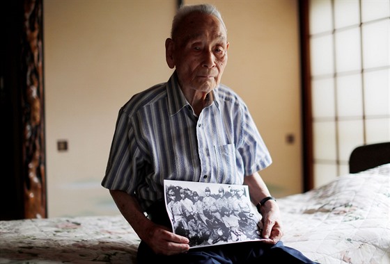Lee Hak-rae pózuje s fotografií, která byla v roce 1942 poízena v jednom ze...