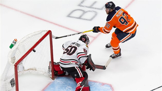 Connor McDavid z Edmontonu překonává Coreyho Crawforda v brance Chicaga. Connor McDavid z Edmontonu překonává Coreyho Crawforda v brance Chicaga.
