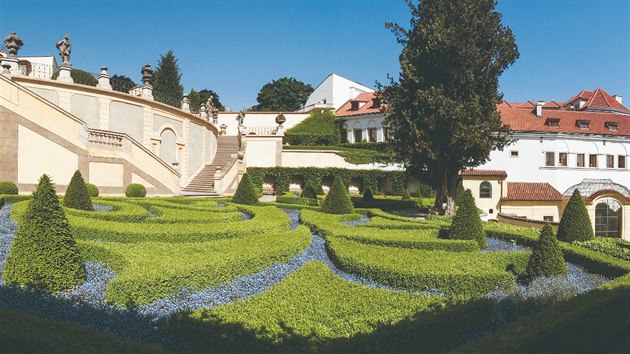 Pohled z druhé terasy. Asymetrii pozemku vyřešil F. M. Kaňka vysázením jabloňového sadu po levé straně, čímž oba ozdobné záhony lícují k středové ose. Zelené francouzské okno vpravo vede do ateliéru Mikoláše Alše. Okna nad voliérou patří hotelu Aria a vznikla zde až po roce 2000.