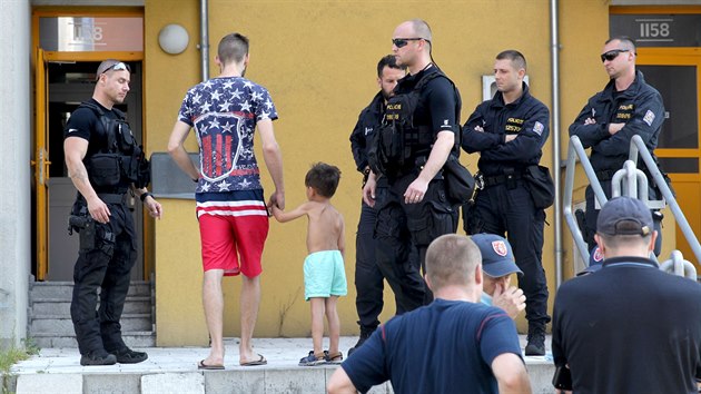 Evakuovan njemnci se za asistence policie vracej po zsahu do domu. (10. srpna.2020)