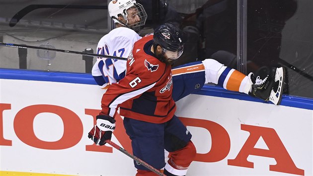 Washingtonsk obrnce Michal Kempn (v poped) atakuje u mantinelu Lea Komarova z New York Islanders.