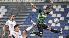 Francesco Caputo (vpravo) ze Sassuola skáe za balonem v zápase proti Cagliari.