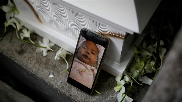 Vznn aktivistka Reina Mae Nasinov se v ochrannm odvu a poutech lou se svou zesnulou dcerou na hbitov v Manile. (16. jna 2020)