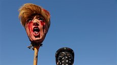 Mu v neworském Manhattanu drí masku poraeného Donalda Trumpa.. (7. listopadu...
