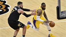 LeBron James z Los Angeles Lakers se tlačí přes Jonase Valanciunase z Memphisu. LeBron James z Los Angeles Lakers se tlačí přes Jonase Valanciunase z Memphisu.