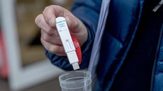Pracovníci magistrátu předvádějí test na covid-19 ze slin před základní školou... Pracovníci magistrátu předvádějí test na covid-19 ze slin před základní školou...