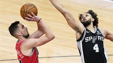 Tomáš Satoranský (vlevo) z Chicaga střílí na koš San Antonia přes Derricka... Tomáš Satoranský (vlevo) z Chicaga střílí na koš San Antonia přes Derricka...