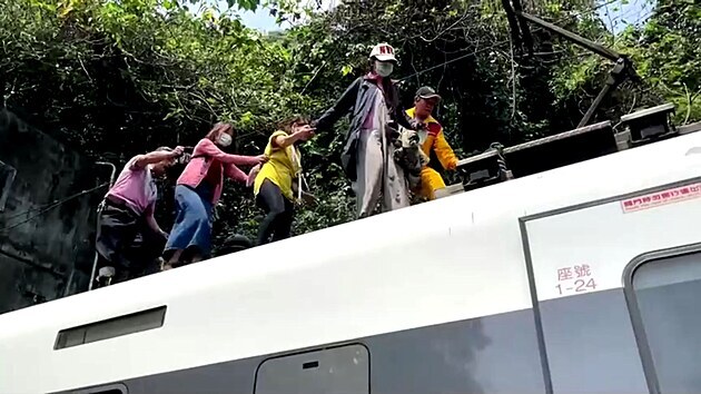 Cestujc odchz po stee vagnu vykolejenho vlaku. Vlak se na vchod Tchaj-wanu srazil s kamionem. (2. dubna 2021)