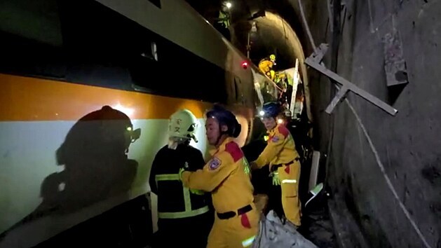Zchrani pracuj se v tunelu pokou osvobodit uvznn lidi v pokozench vagnech vykolejenho vlaku, kter se srazil na vchod Tchaj-wanu srazil s kamionem. (2. dubna 2021)
