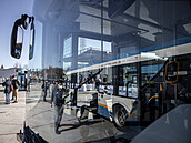 Ve skle ekologického dvoupatrového autobusu se odráží starší typ vozu s... Ve skle ekologického dvoupatrového autobusu se odráží starší typ vozu s...