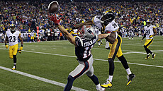 Julian Edelman (11) z New England Patriots se marn natahuje po míi v zápase s...