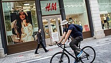 Cyklista projíždí kolem zavřené pobočky oděvního řetězce H&M v řeckých... Cyklista projíždí kolem zavřené pobočky oděvního řetězce H&M v řeckých...