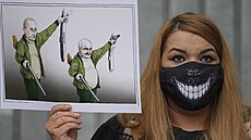 Osoba drží karikaturu zobrazující běloruského prezidenta Alexandra Lukašenka a... Osoba drží karikaturu zobrazující běloruského prezidenta Alexandra Lukašenka a...