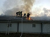 Hasiči se snaží dostat do střešních prostor. Hasiči se snaží dostat do střešních prostor.