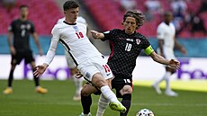 Mason Mount (vlevo) odehrává míč před napadajícím Lukou Modričem. Mason Mount (vlevo) odehrává míč před napadajícím Lukou Modričem.