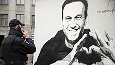 Policista mluví po telefonu poblíž grafitů ruského uvězněného vůdce opozice... Policista mluví po telefonu poblíž grafitů ruského uvězněného vůdce opozice...