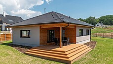 Dřevěná terasa je šikovně vpasována do vykrojeného půdorysu domu. Dřevěná terasa je šikovně vpasována do vykrojeného půdorysu domu.