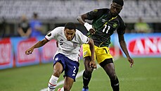 Americký fotbalista Reggie Cannon (vlevo) v souboji s Darylem Dikem z Jamajky. Americký fotbalista Reggie Cannon (vlevo) v souboji s Darylem Dikem z Jamajky.