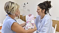 Porodní asistentka Markéta Zemanová podává novorozené dítě jeho matce Zdeňce... Porodní asistentka Markéta Zemanová podává novorozené dítě jeho matce Zdeňce...