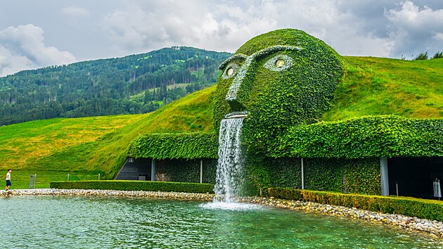 Swarovski, Innsbruck. Zelení porostlá fontána ve tvaru lidské hlavy se...
