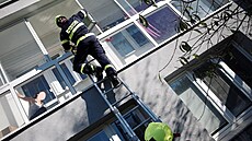Záchrana probíhala jak dveřmi bytu, tak balkonem, kde byla uvězněná matka... Záchrana probíhala jak dveřmi bytu, tak balkonem, kde byla uvězněná matka...