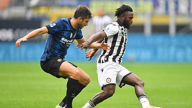 Isaac Success (vpravo) z Udinese kontroluje balon, zezadu ho napad Andrea Ranocchia z Interu Miln.