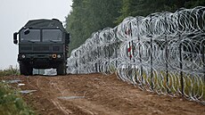 Pohled na vozidlo vedle plotu postaveného polskými vojáky na hranici mezi...