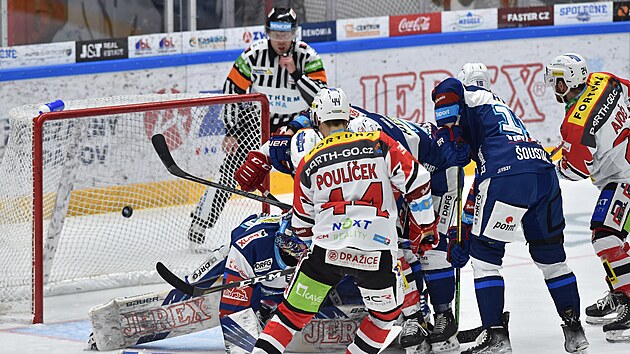 Kometa Brno (modrá) vs. Pardubice. Puk z hole Lukáše Anděla (vpravo) míří do branky domácích.