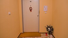 Před bytem zavražděné seniorky leží svíčky a na zdi visí parte. (28.12. 2021) Před bytem zavražděné seniorky leží svíčky a na zdi visí parte. (28.12. 2021)