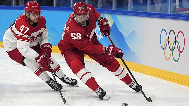 Ruský útočník Anton Slepyšev si kryje puk před Oliverem Larsenem z Dánska.