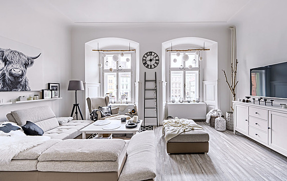 Obývací pokoj je stejn jako celý byt v bílé barv, lehce doplnnou edou a...