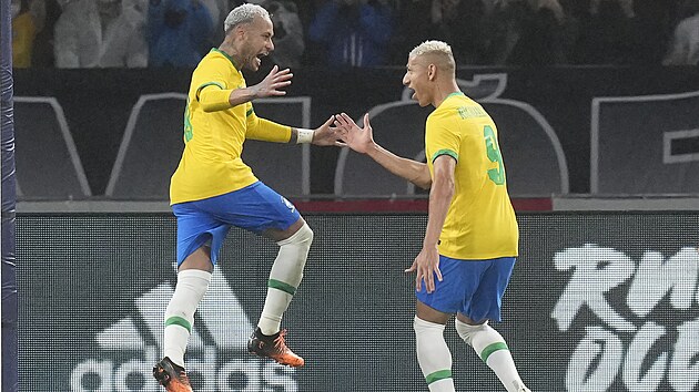 Brazilsk fotbalista Neymar se raduje se spoluhrem Richarlisonem z glu v zpase s Japonskem.