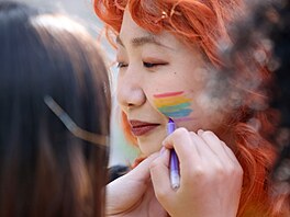 Úastníci festivalu Pride se navzájem zdobili duhovou barvou.