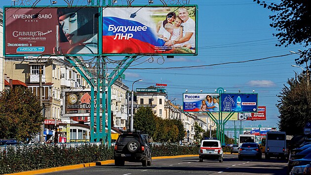 Auto projdjc pod billboardy s proruskmi slogany v Luhansku na Ukrajin. (20. z 2022)