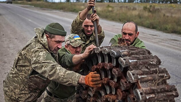 Ukrajint vojci nakldaj psy ze znienho obrnnho transportru, kte Rusov zanechali u osvobozenho msta Izjum. (24. z 2022)