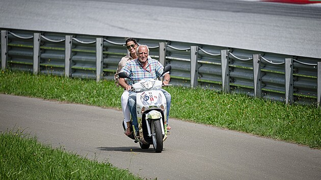 Dietrich Mateschitz, majitel Red Bullu, jede se svou ptelkyn na sktru kolem okruhu kvalifikace Velk ceny Rakouska MotoGP. (10. srpna 2019)