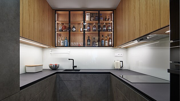 Kuchy ve tvaru U kombinuje dekor betonu, dubu a ernho kompaktnho lamintu.